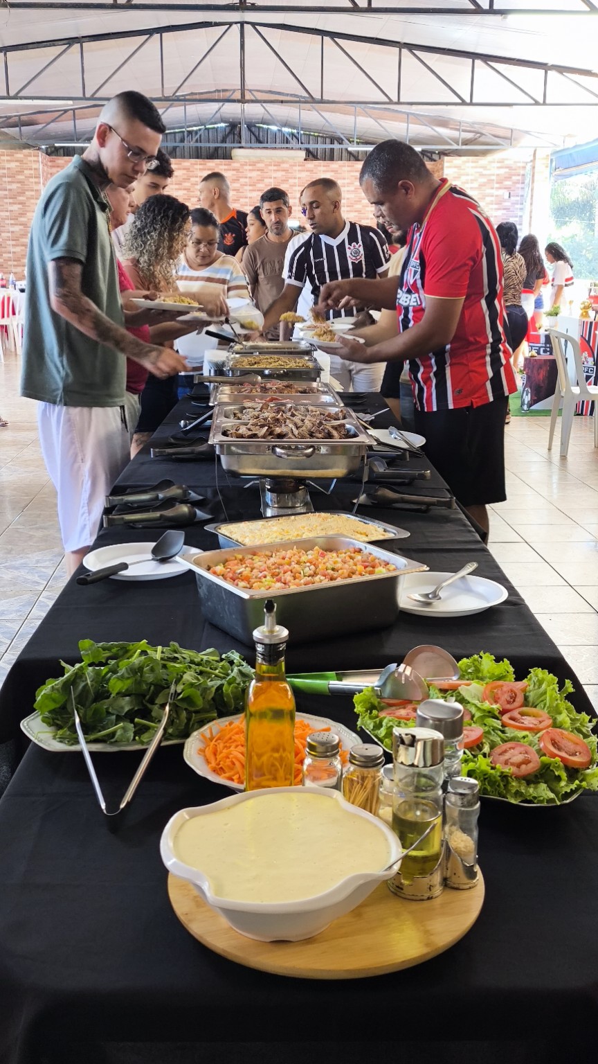 Convidados se servindo em um buffet de aniversário