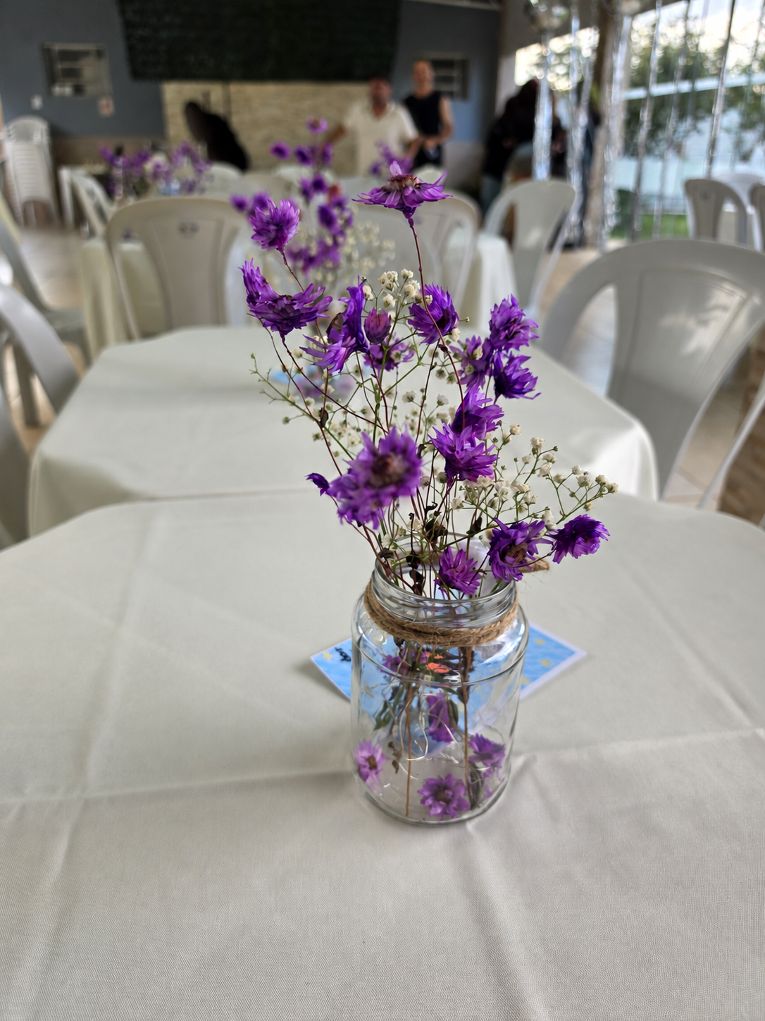 Arranjo de flores roxas na mesa da celebração