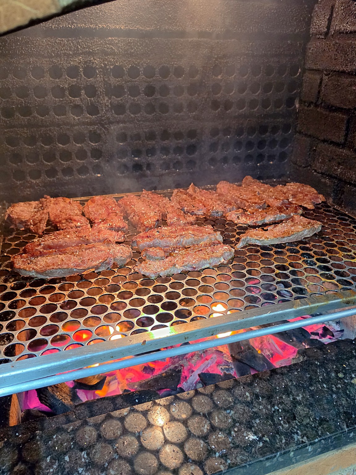 Carnes sendo preparadas na churrasqueira