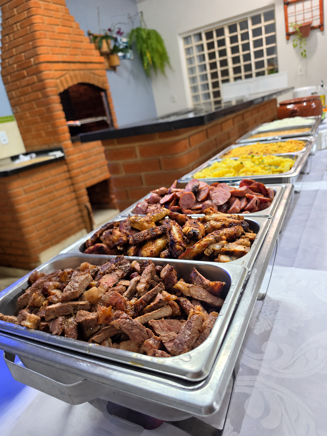 Buffet com carnes e acompanhamentos em uma celebração de debutante