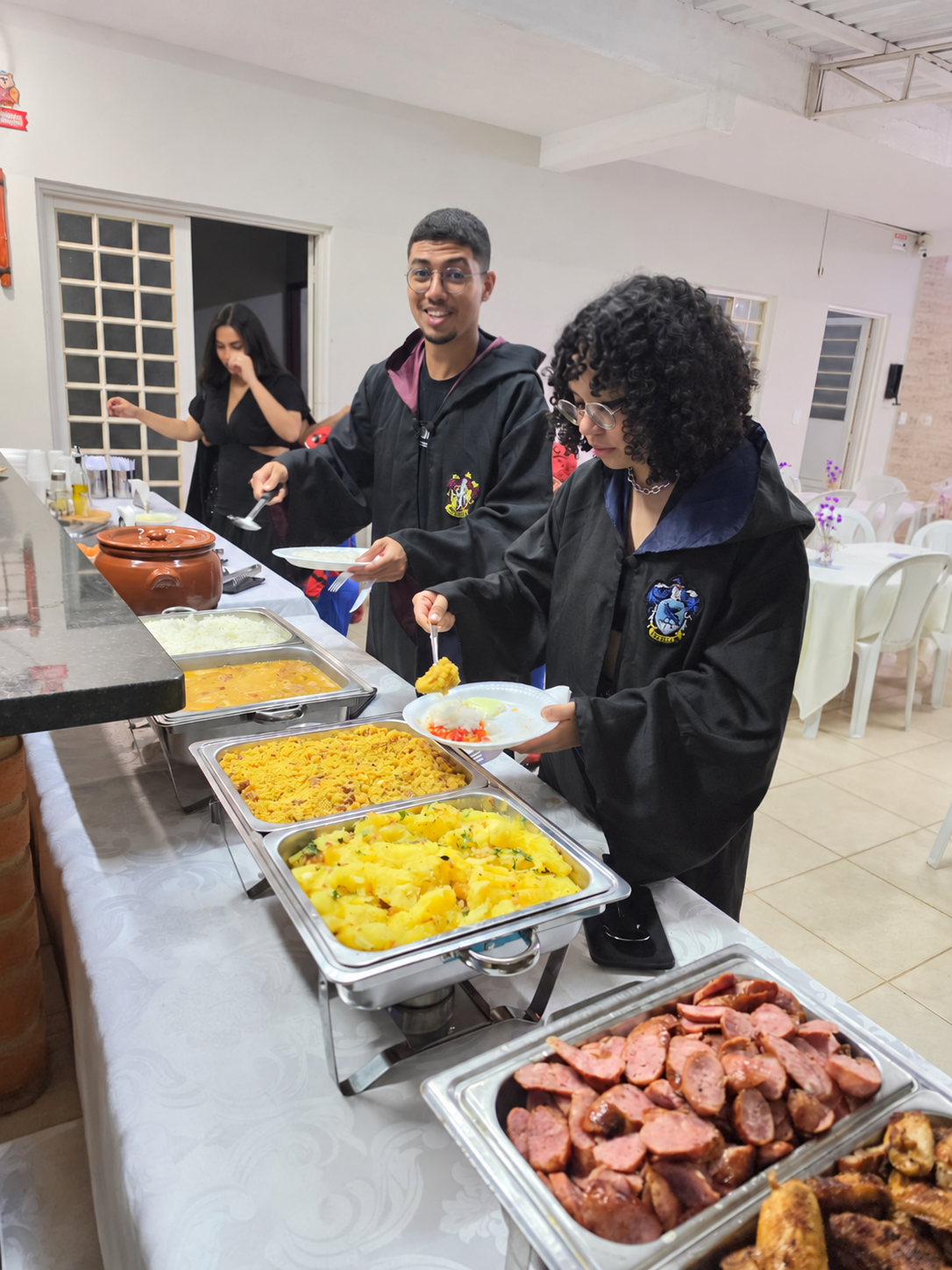 Convidados se servindo no buffet da celebração