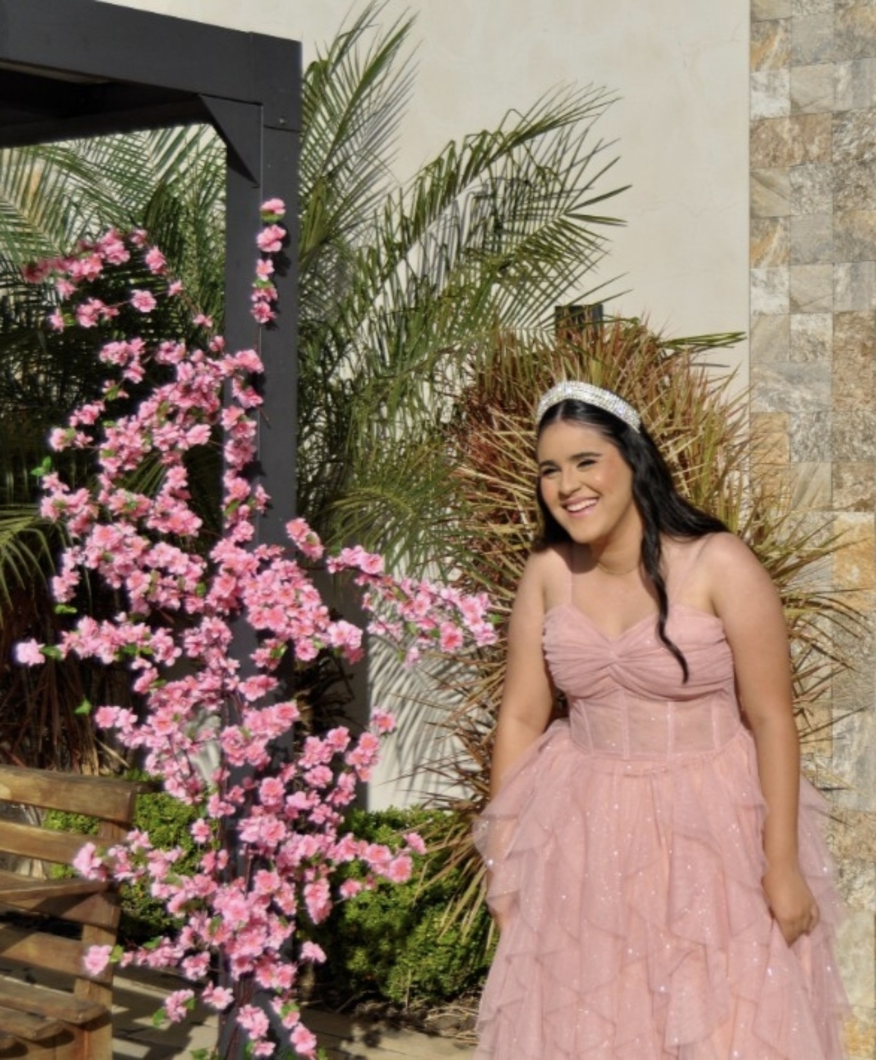 Debutante sorrindo junto à decoração floral